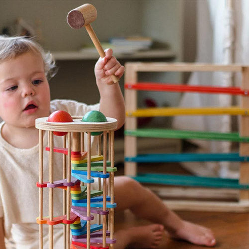 child playing with Qtoys pound a ball tower with Track a Ball rack in the background