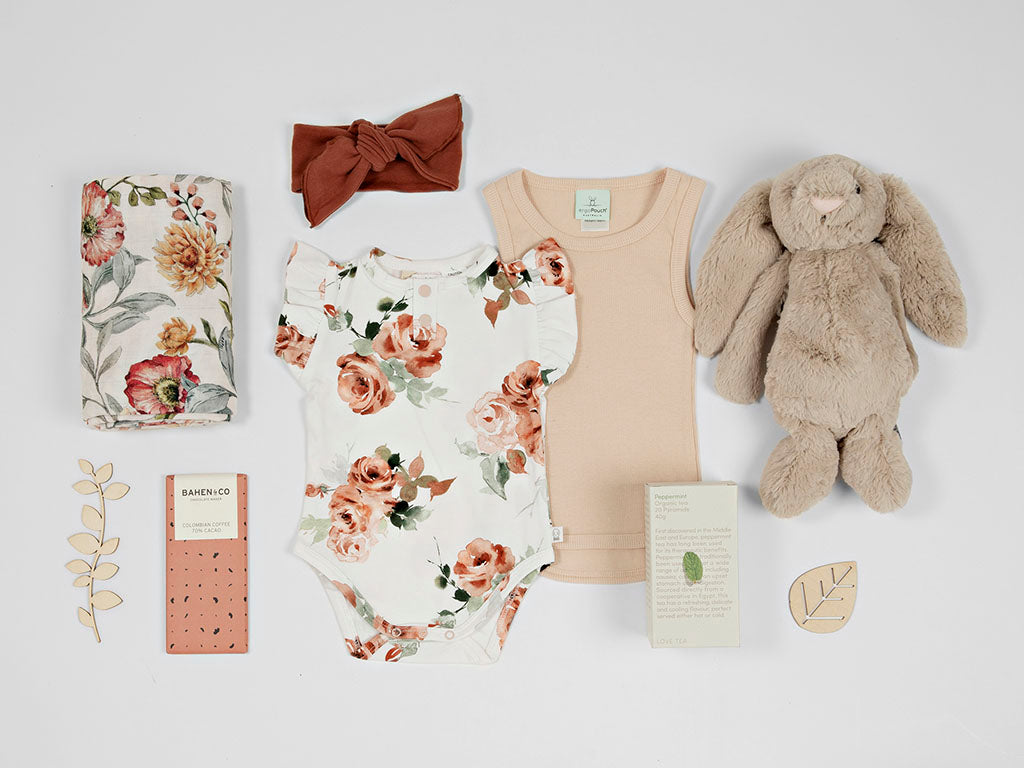 Rose baby girl gift hamper flat lay from young willow