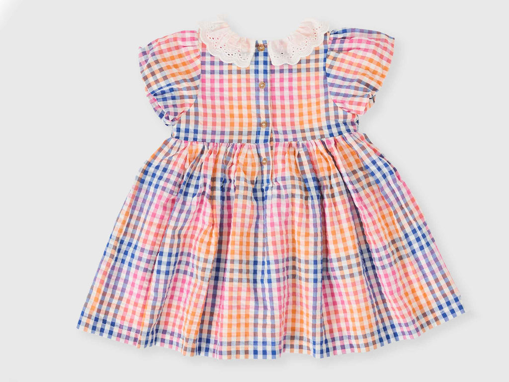 Colorful checkered dress with a white collar on a light gray background