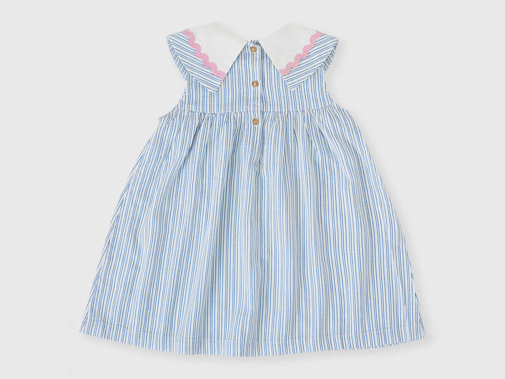 Blue and white striped dress with pink trim on a light gray background