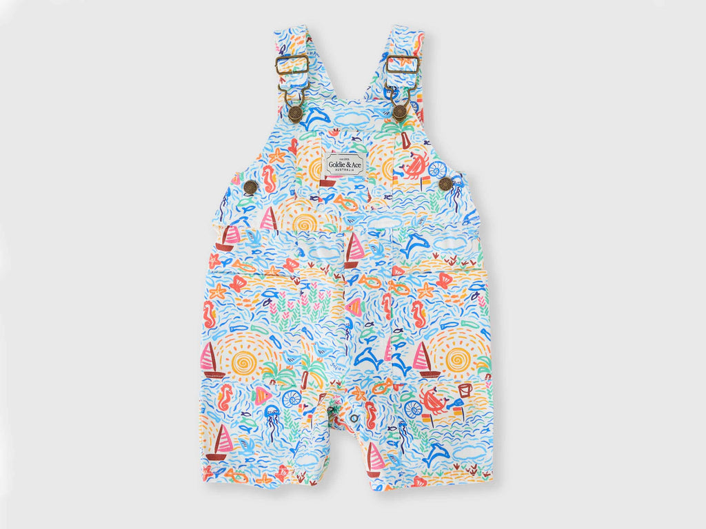 Colorful children's overalls with a sea-themed pattern on a light gray background