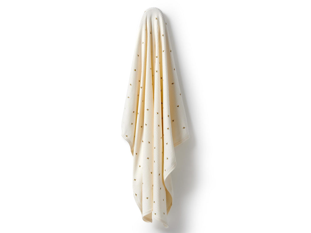 White blanket with bee print on a white background