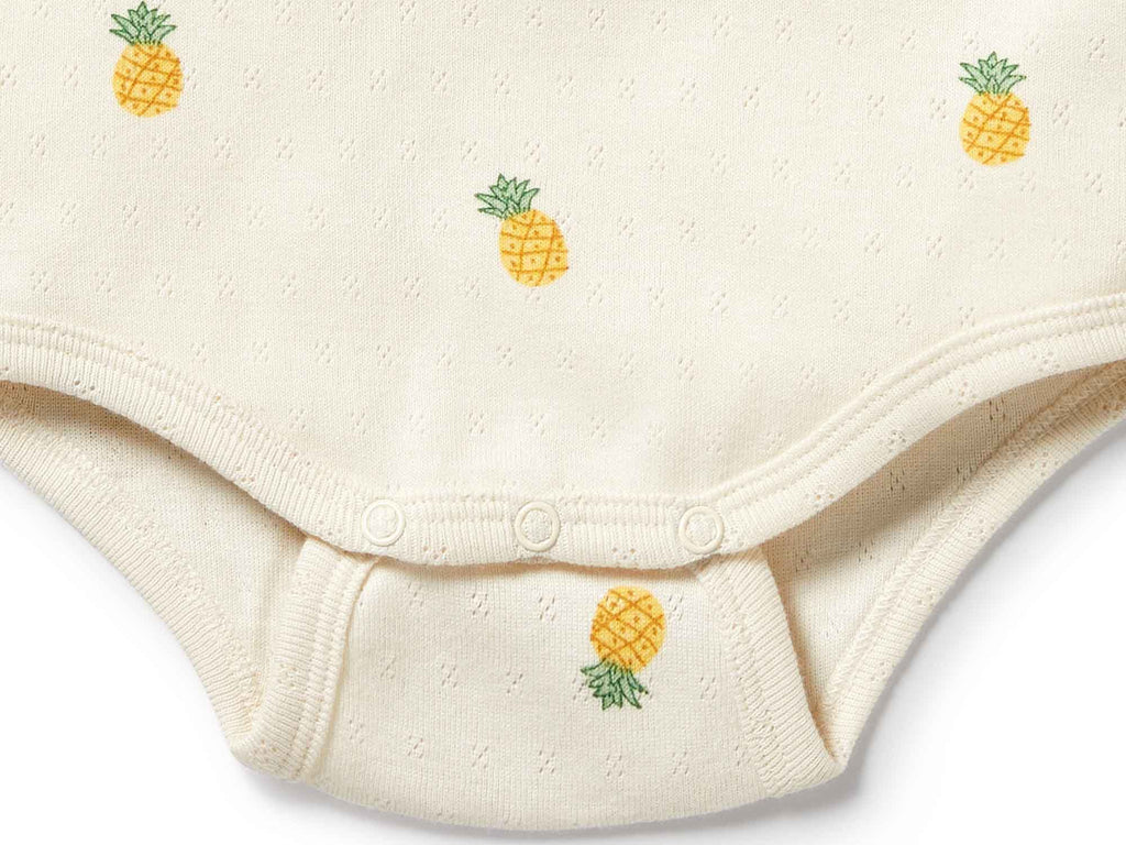 Beige baby onesie with pineapple patterns on a white background