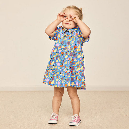A girl wearing Goldie and Ace's fruit tingle dress in blue and making cute faces