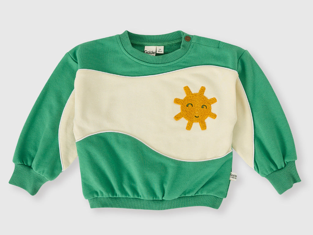 Green and beige sweatshirt with a sun design on a white background