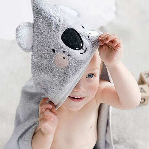 child wearing a Mister Fly hooded Koala towel and playing peekaboo