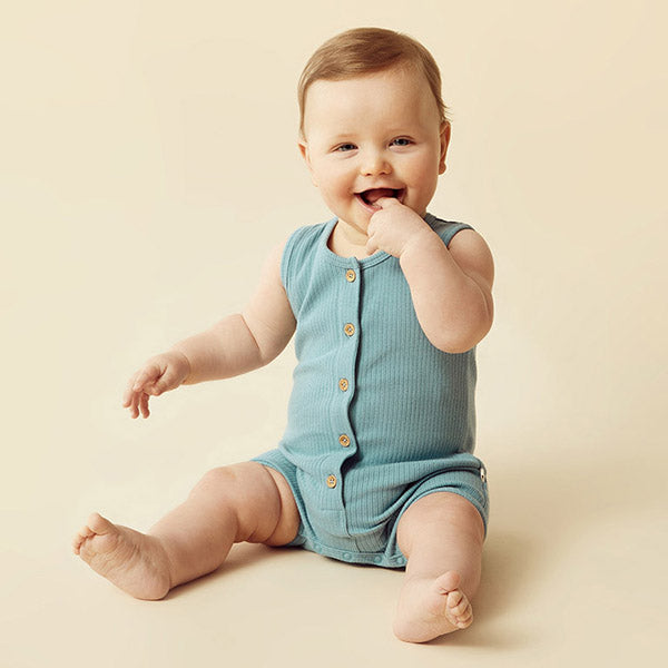 baby boy sitting whilst wearing a blue romper by wilson and frenchy