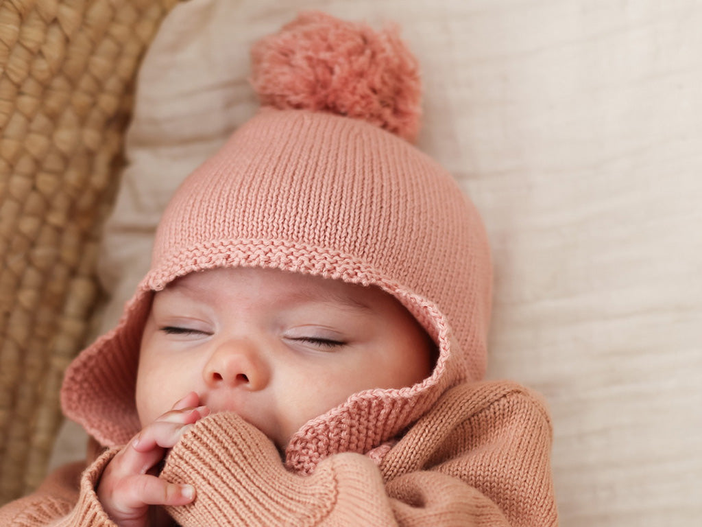 Baby wearing the Burrow & be tan rose knit bonnet