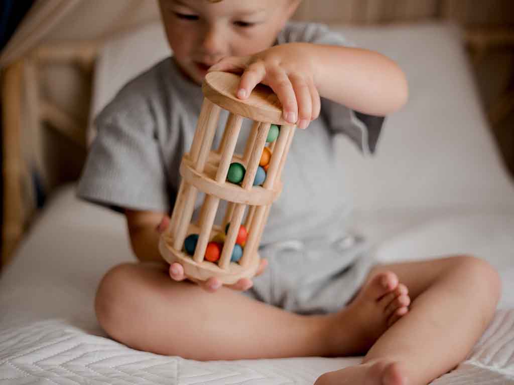 Qtoys mini rainmaker wooden toys for babies at young boy playing with it Young Willow